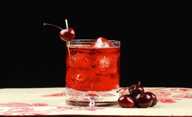 glass of cherry liqueur with cherries on side